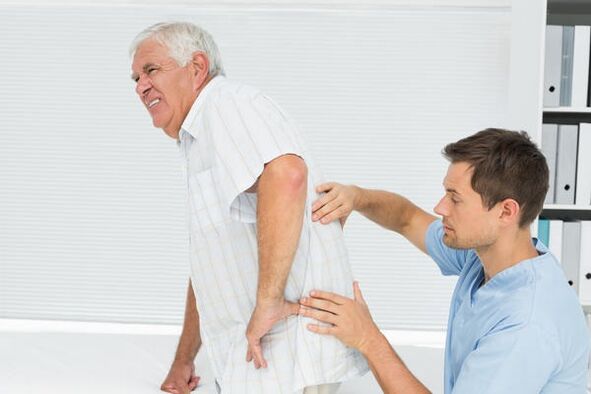 Vyresnio amžiaus pacientas, turintis juosmens skausmą, kurį mato gydytojas